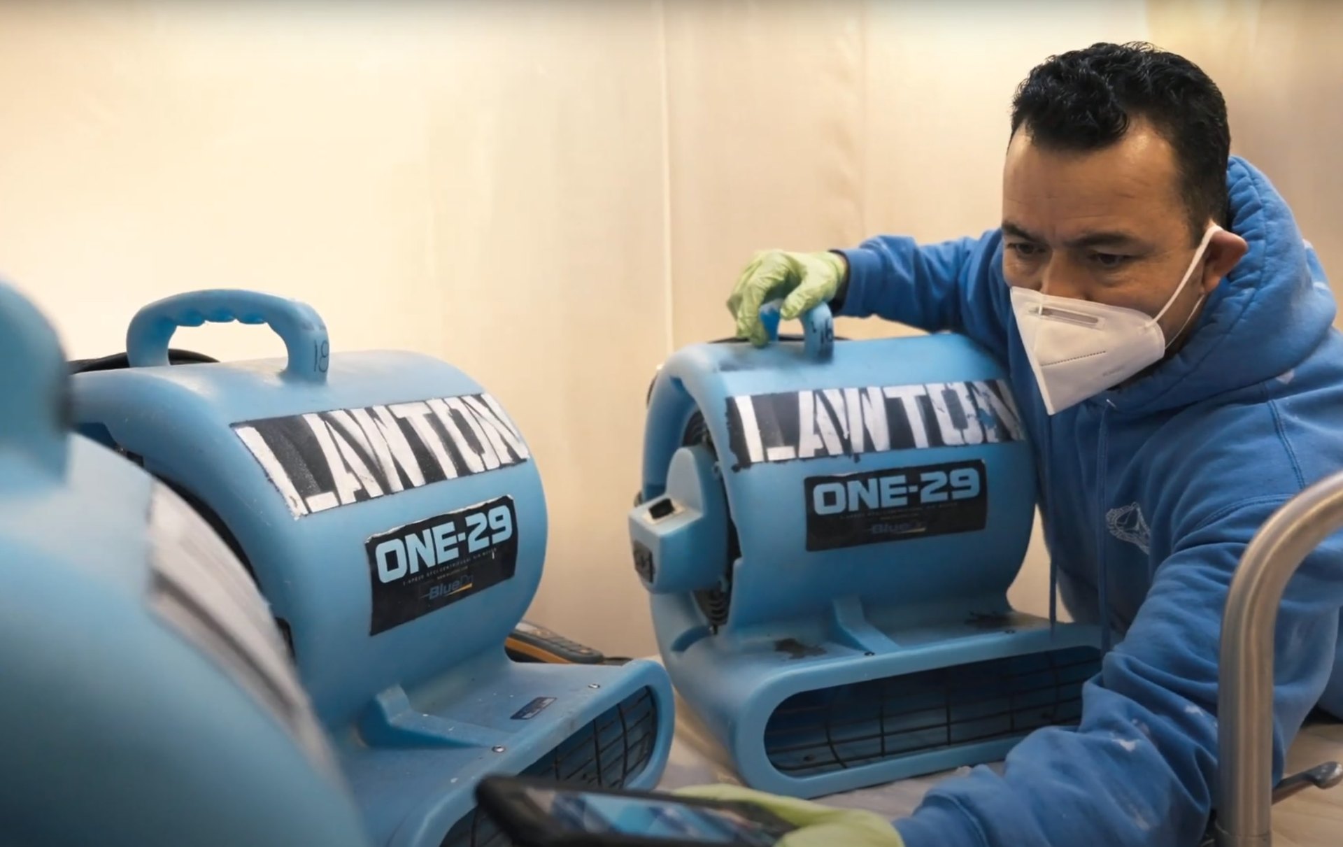 Professional water damage restoration technician using industrial drying equipment